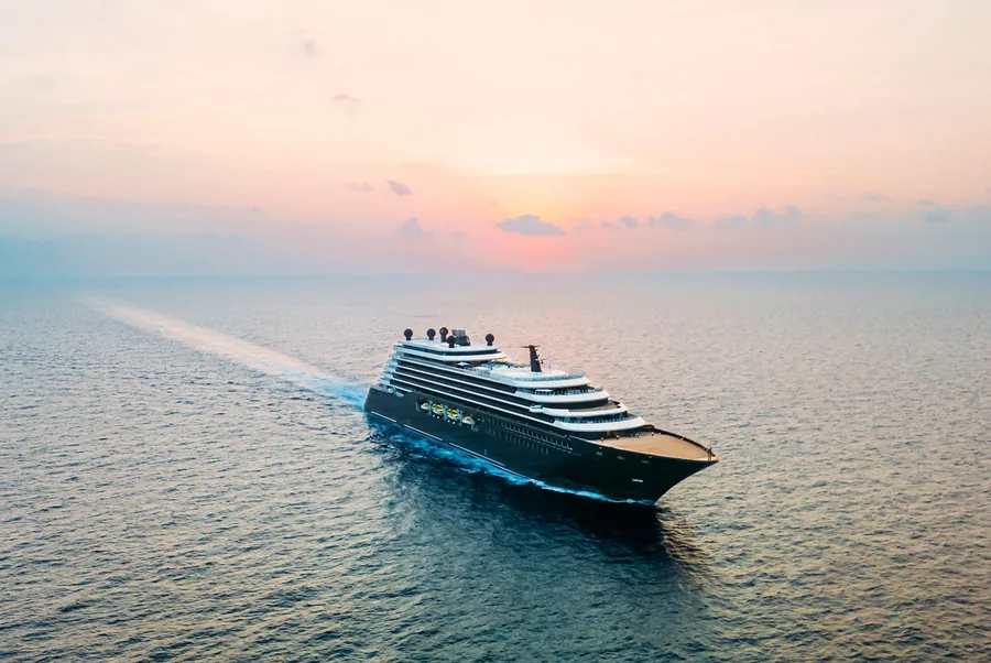 Ilma of The Ritz-Carlton Yacht Collection under way on the open sea beneath a pink sky